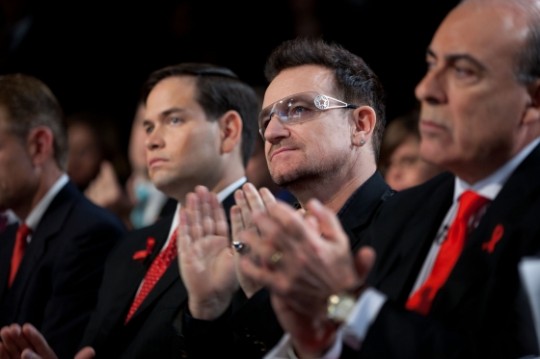 Musician Bono, center, listens as President Barack Obama delivers remarks at a World AIDS Day event at George Washington University in Washington, D.C., Dec. 1, 2011. (Official White House Photo by Pete Souza)