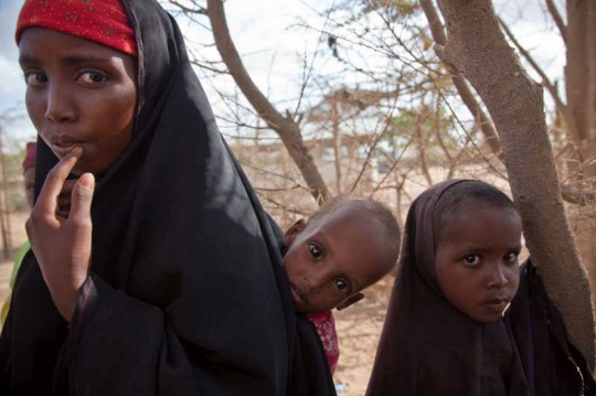 A displaced woman with two children after fleeing their home in southern Somalia. Photo: UNHCR/B.Bannon