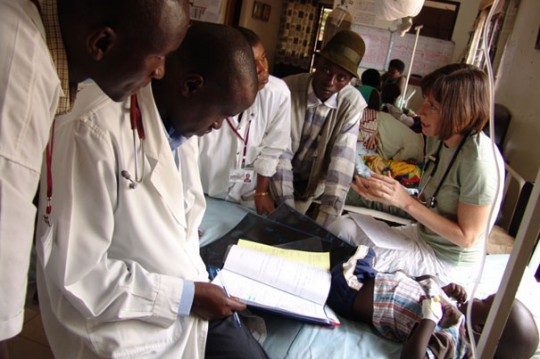 Sara Stulac (right), consults with colleagues at the Rwinkwavu Hospital in Eastern Rwanda. Stulac, who is a Harvard Medical School instructor in medicine and the director of pediatrics for Partners In Health, has designed a program that brings together Rwandan physicians with Boston-based pediatric oncologist./ Photos courtesy of Partners In Health