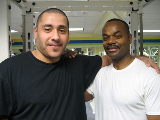 Burgos (left) takes a moment to pose with Eric McCloud (right) of Environmental Services, who befriended him years back and has since encouraged him shape up. Burgos also credits Bernard Williams (not pictured), also of Environmental Services, for lending him support on his weight loss journey.