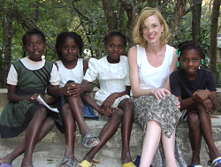 Four young girls pose with Sue Goldie, a MacArthur “genius” award winner, in Haiti.