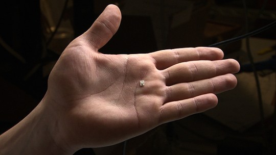 The current prototype chip, shown here resting on a hand, is only three millimeters wide and four millimeters long.