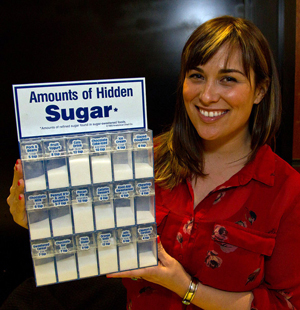 Valerie Taormina, community relations manager at the American Heart Association, holds up a display about hidden sugar found in common foods.