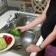 Properly preparing fresh, uncooked produce ... Pregnant woman in the process of washing a batch of assorted ...